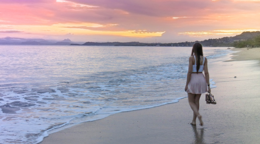 girl walking on beach in sunset 